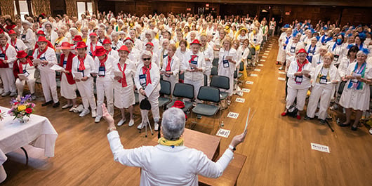 alums wearing white and singing in Chapin Hall during Reunion
