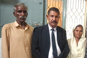 Attorney Hanif Hameed is standing between the parents of unnamed 15-year-old.