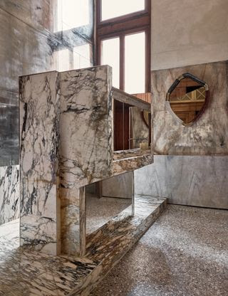 En el baño principal revestido de espejos, hay un lavamanos monumental y una ducha tallada en mármol breccia di seravezza.