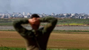An Israeli soldier gestures as he looks in the direction of the destroyed homes in north Gaza during Israels genocidal war on Gaza on 31 January 2024 Reuters .jpg