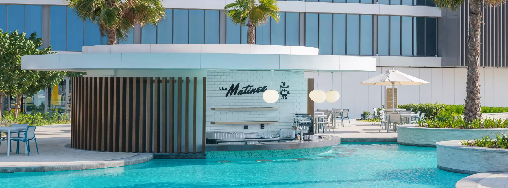 A pool with a building in the backgroundDescription automatically generated