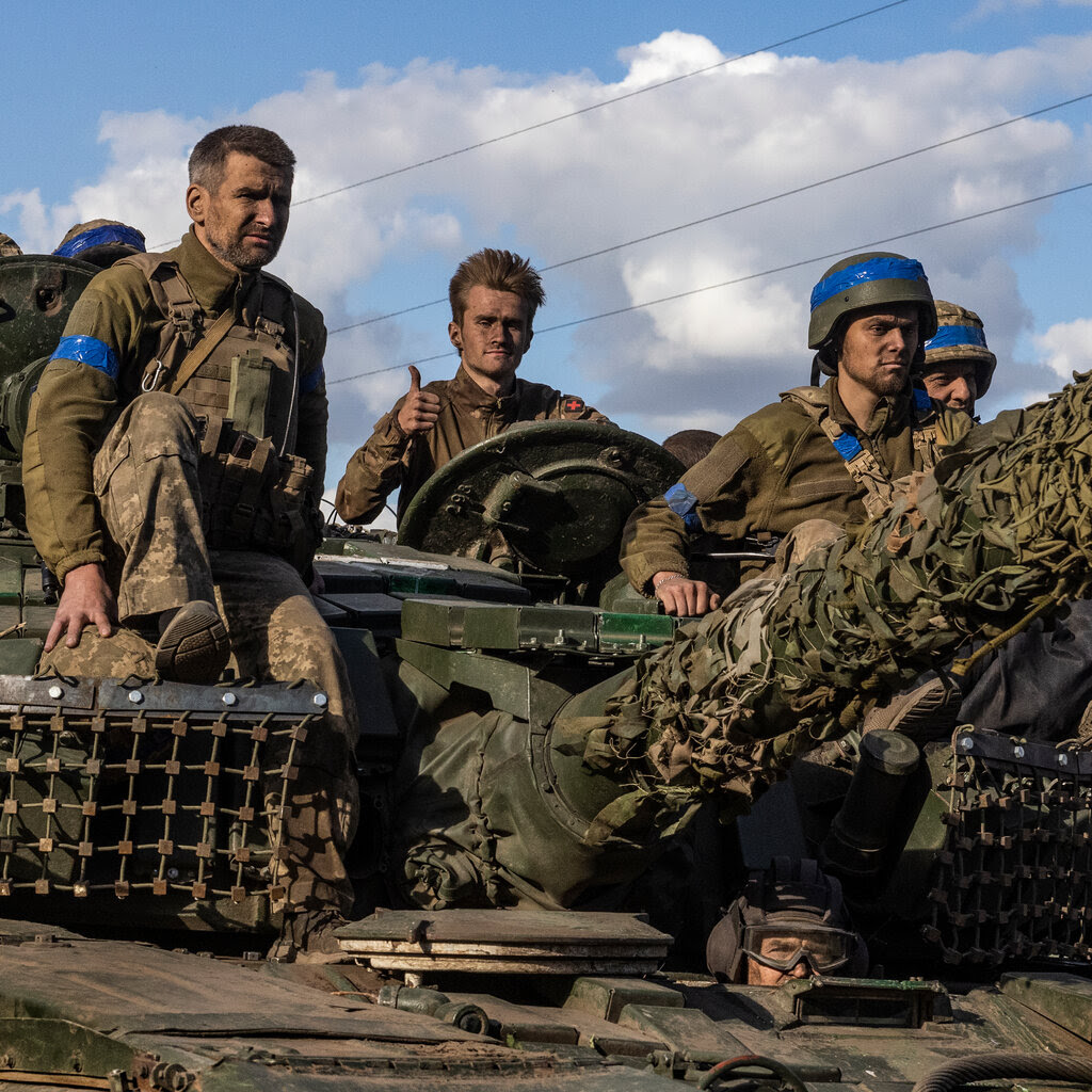 Troops seen atop a tank.