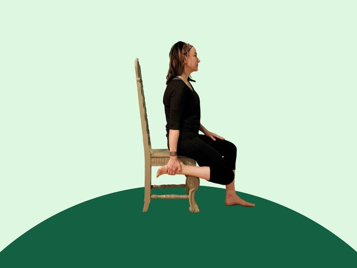 Woman doing chair yoga King Arthur's pose on green background.