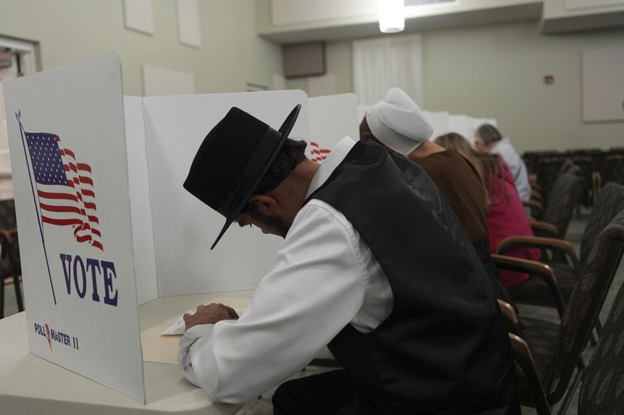 Members of the Amish community wearing traditional Amish clothing cast their votes.