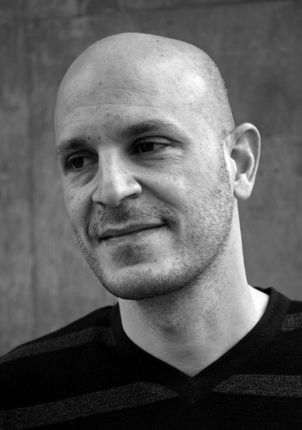 A black-and-white headshot of Fady Joudah in a horizontally striped sweatshirt.