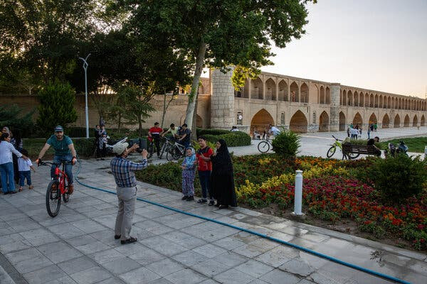 Tourists pose for pictures in a garden.