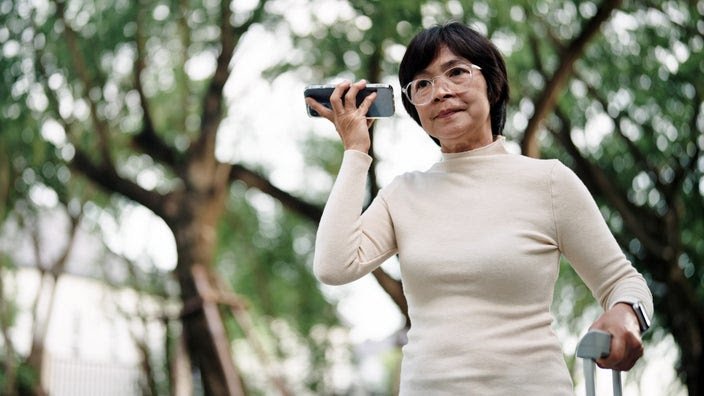 Older woman places a smartphone to her ear.