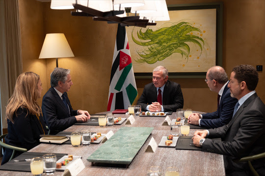 Secretary Blinken meets Jordanian King Abdullah and three others around a table with food.