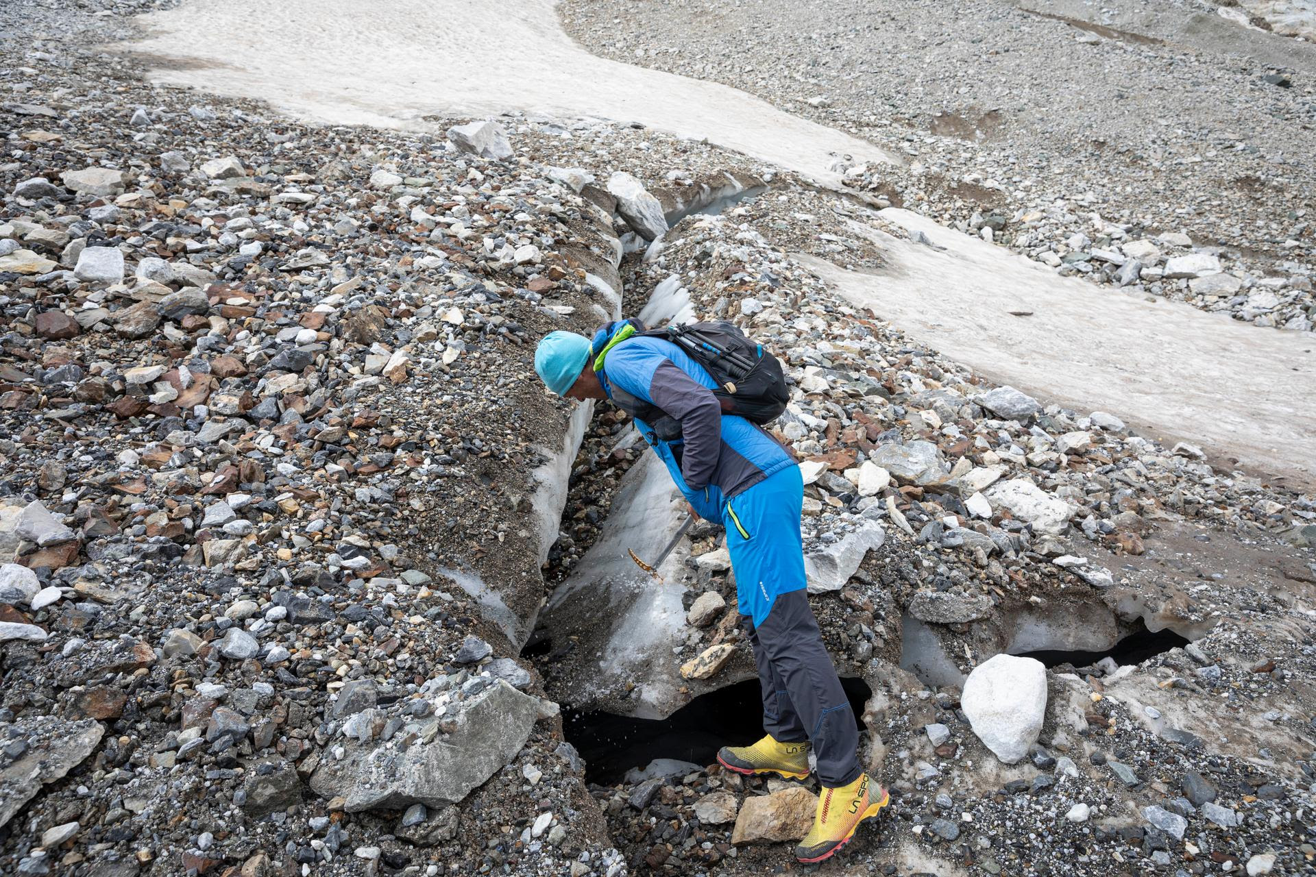 Pierre René, glaciologue, examine une fracture à la surface de la partie basse du glacier des Oulettes de Gaube, le 19 septembre 2024.