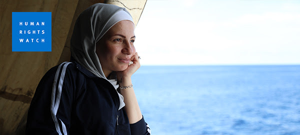 Une femme portant un hijab regarde depuis un navire de sauvetage vers la Méditerranée