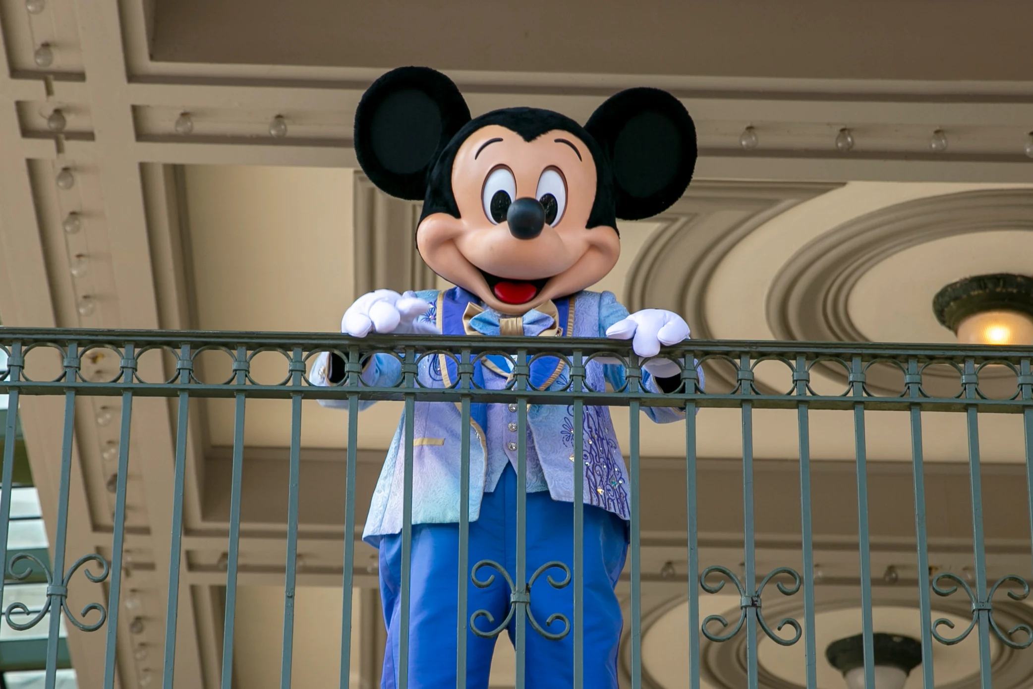 An actor dressed as Mickey Mouse greets visitors.