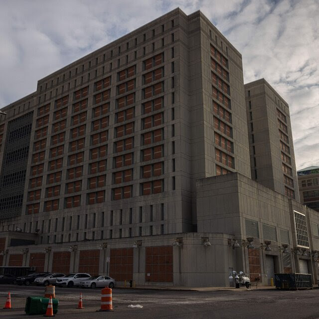 A tall building is partially in silhouette. 