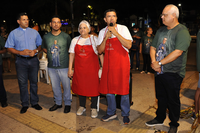 Foto colorida mostra várias pessoas em pé durante evento na Praça Deodoro, no Centro de São Luís. O juiz Douglas de Melo fala ao microfone.