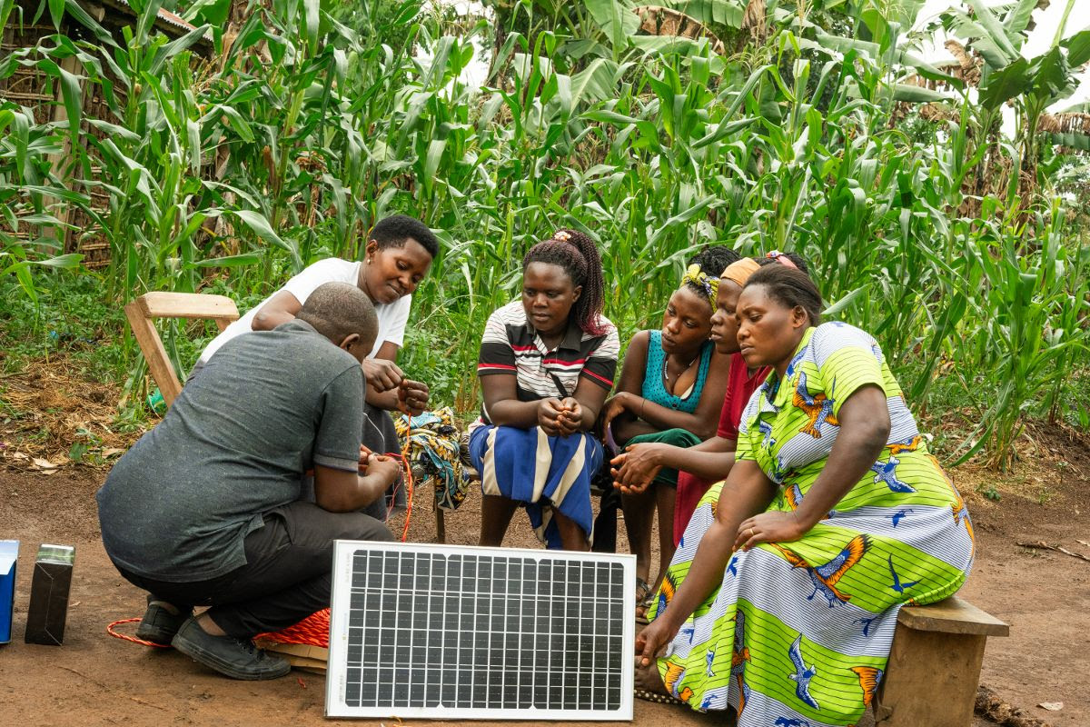 Image depicts member of the local community in Uganda training to build, connect and maintain solar panels