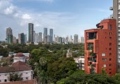 El edificio de color rojo combina bien con el verde de la gran avenida de acacias y se diferencia de los edificios grises que lo rodean.