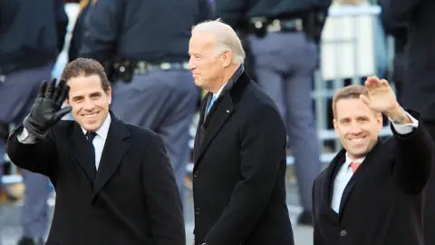 Getty Images Hunter (left), with father Joe and brother Beau, waves at supporters during Barack Obama's inauguration as president