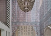 El vestíbulo de doble altura está presidido por un mural lila y malva que simula franjas de tela y una lámpara de araña de 400 kilos.