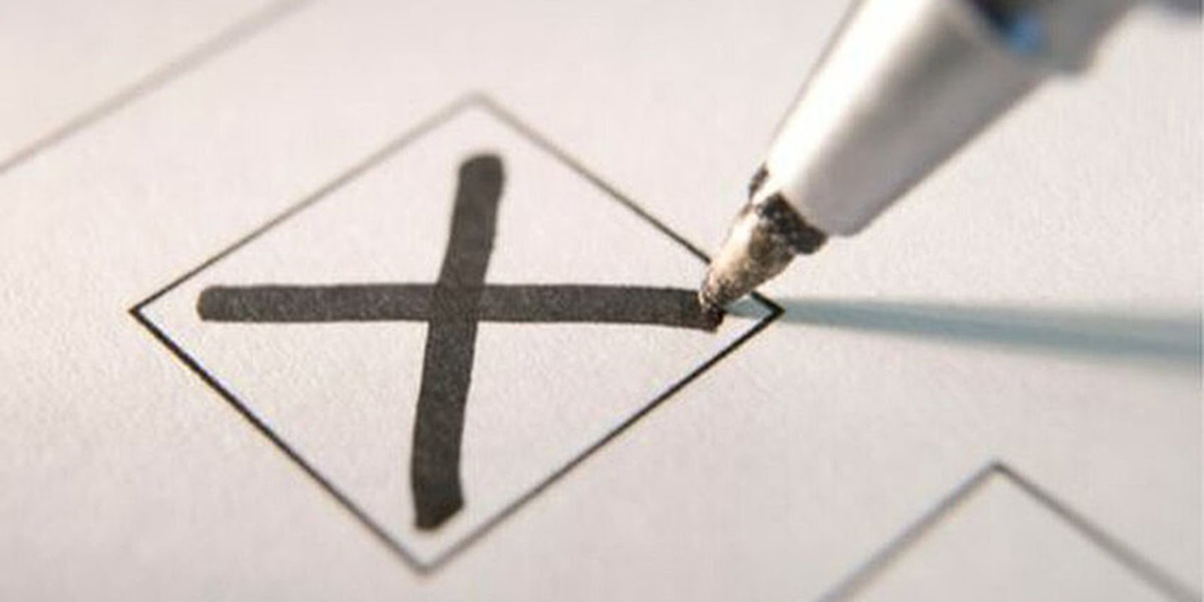 A pen marks an X on a voting card.