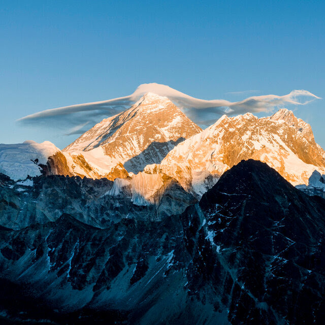 Mount Everest and other Himalayan peaks with a small cloud sitting at the top.