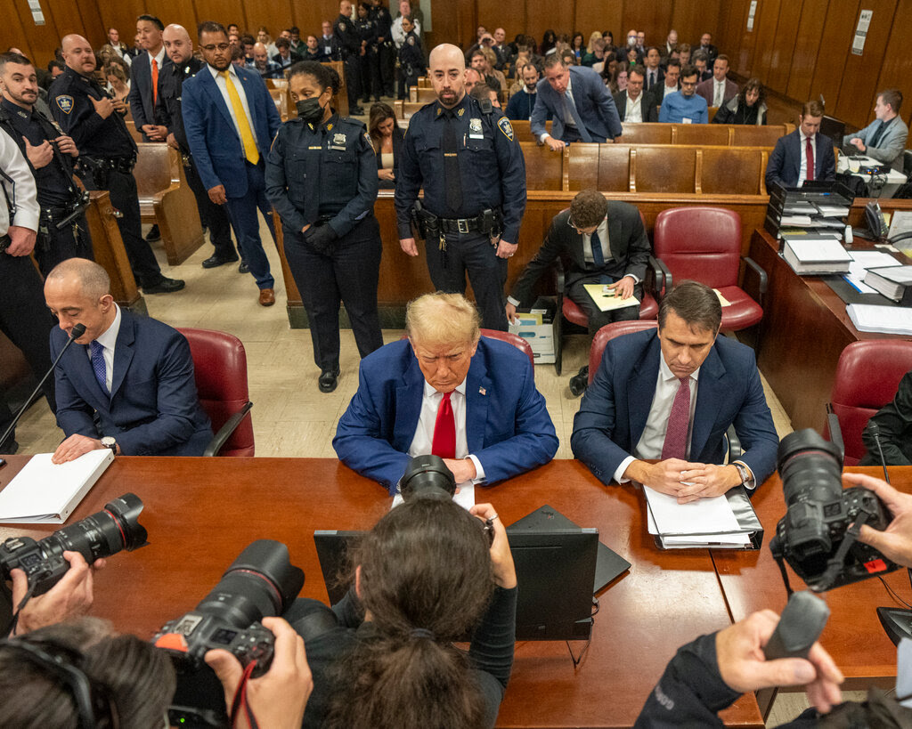 Photographers taking photos of Donald Trump in a courtroom.