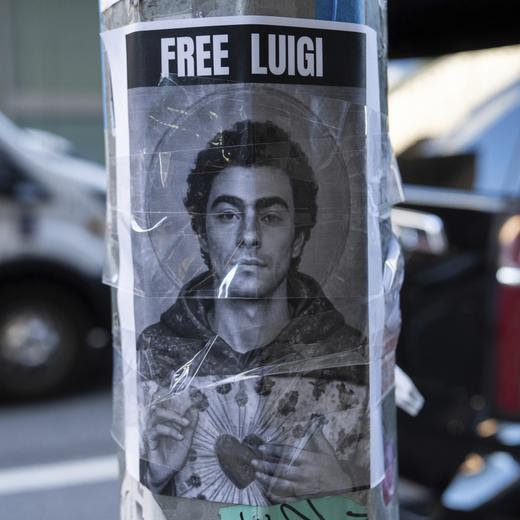 A poster depicting Luigi Mangione hangs outside the New York Hilton Midtown hotel, in New York, Dec. 12, 2024. (AP Photo/Julia Demaree Nikhinson)