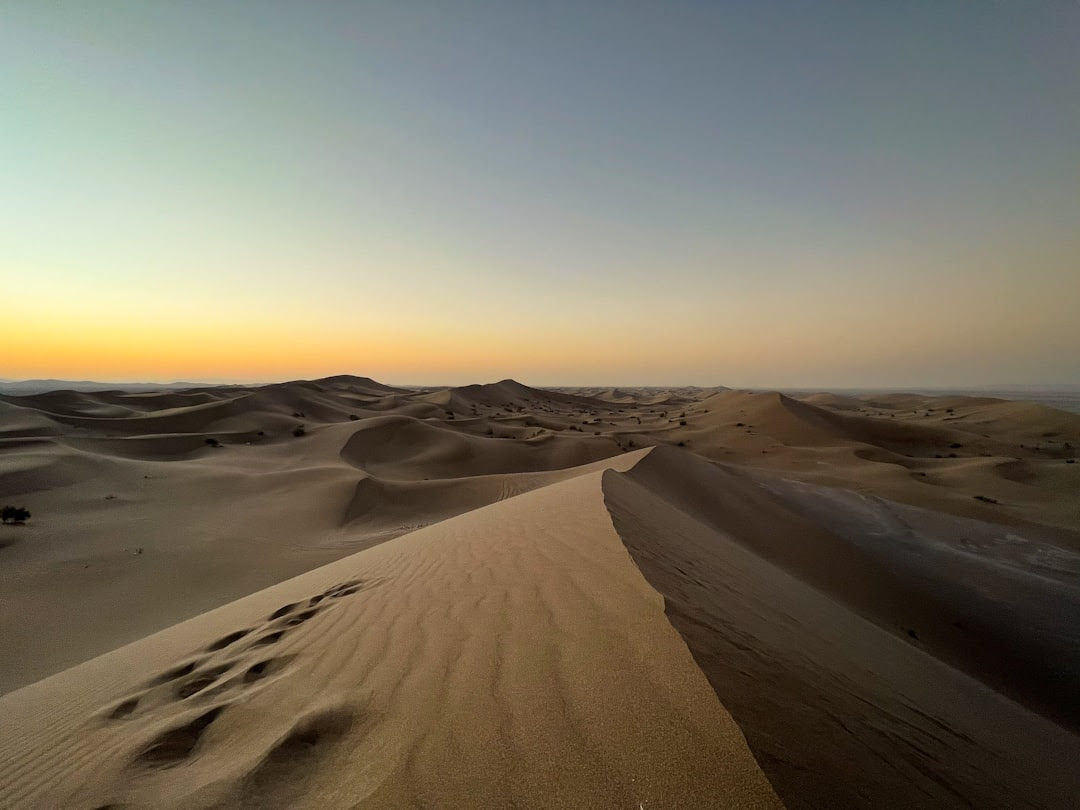 the sun is setting over the sand dunes