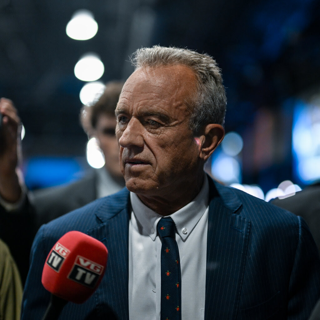 Robert F. Kennedy Jr., in a suit and tie, is seen from his chest up before a microphone.