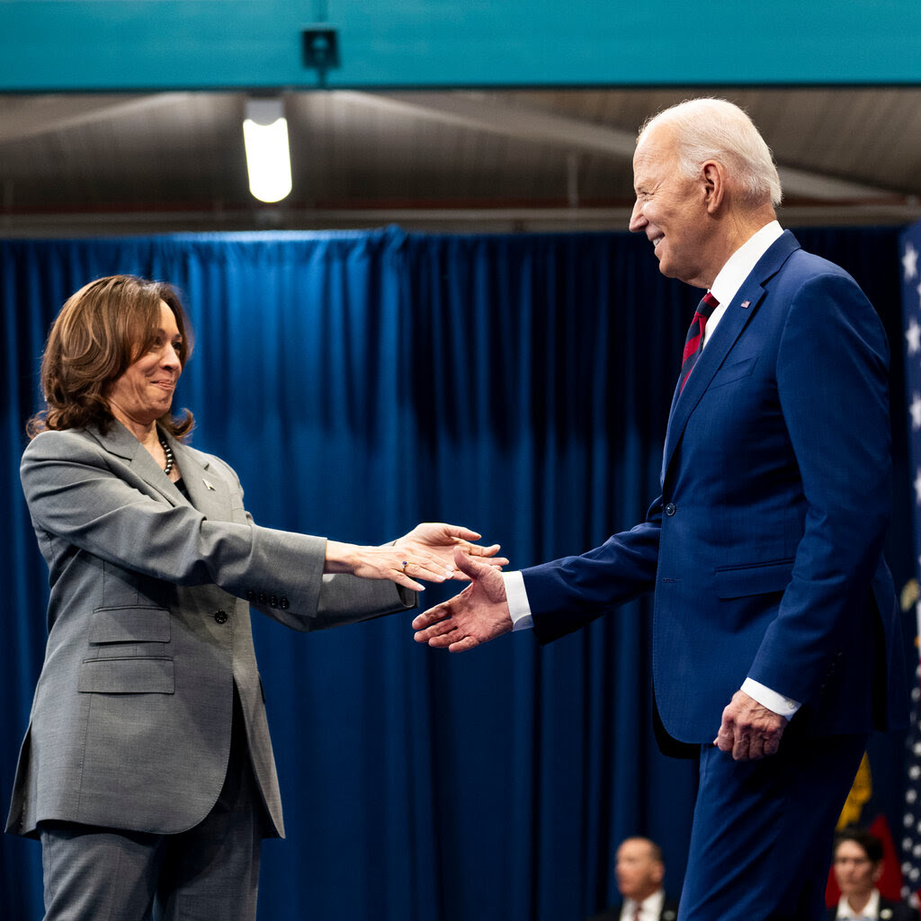 Vice President Kamala Harris reaches out to shake the hand of President Biden.