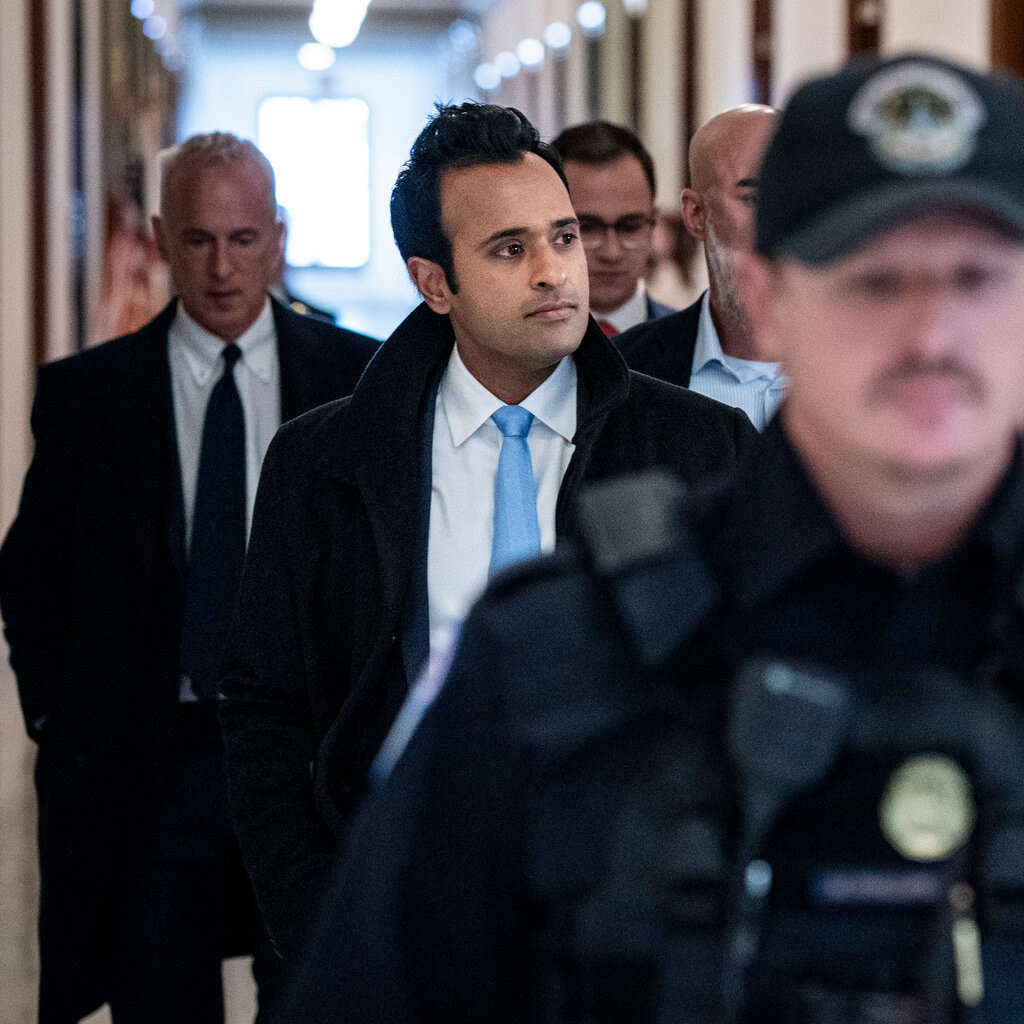 Vivek Ramaswamy flanked by aides.