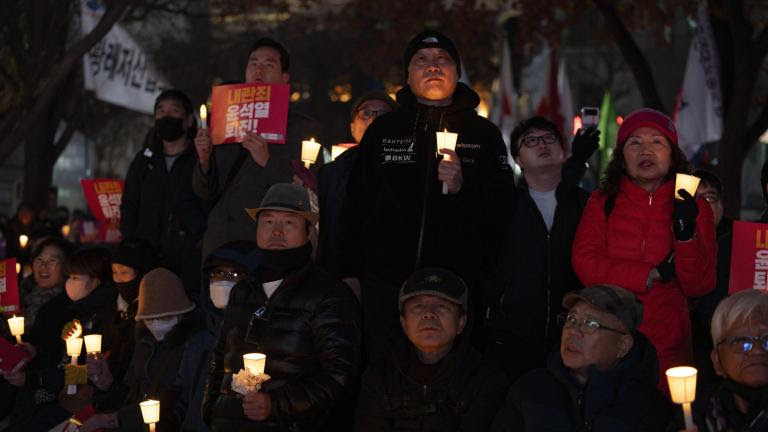 People hold candles during a candlelight vigil against South Korean President Yoon Suk Yeol in Seoul, South Korea, Wednesday, Dec. 4, 2024. (AP Photo/Ng Han Guan)