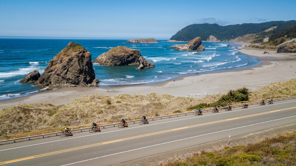 Teen summer adventure camp group cycling down the coast in California 