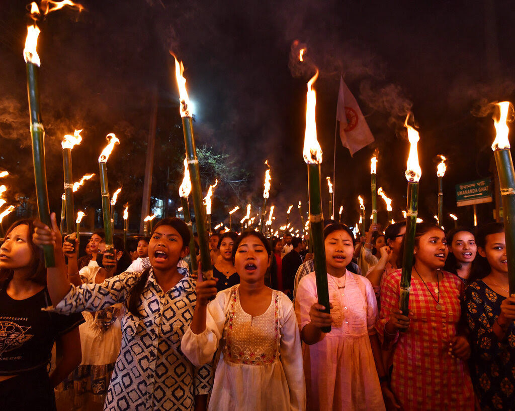 Girls holding torches at an evening protest rally. 