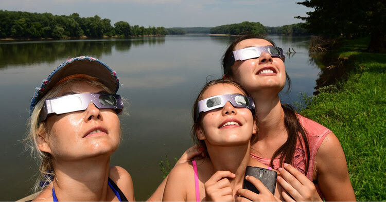 Women wearing eclipse glasses