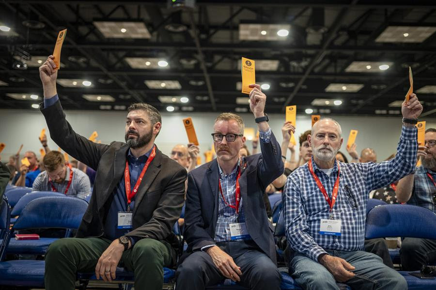 People attending the Southern Baptist Convention's annual meeting hold up orange ballots.