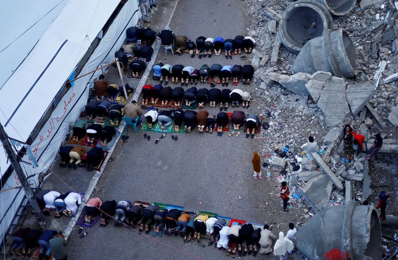 Palestinians hold Eid prayers by the ruins of al-Farouk mosque, in Rafah, southern Gaza Strip. (Mohammed Salem/Reuters)