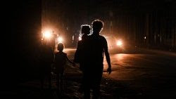 Una famiglia cammina lungo le vie di Cuba nella terza notte di blackout