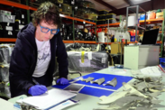 Scientist analyzing specimens and taking notes in a forensic laboratory storage room