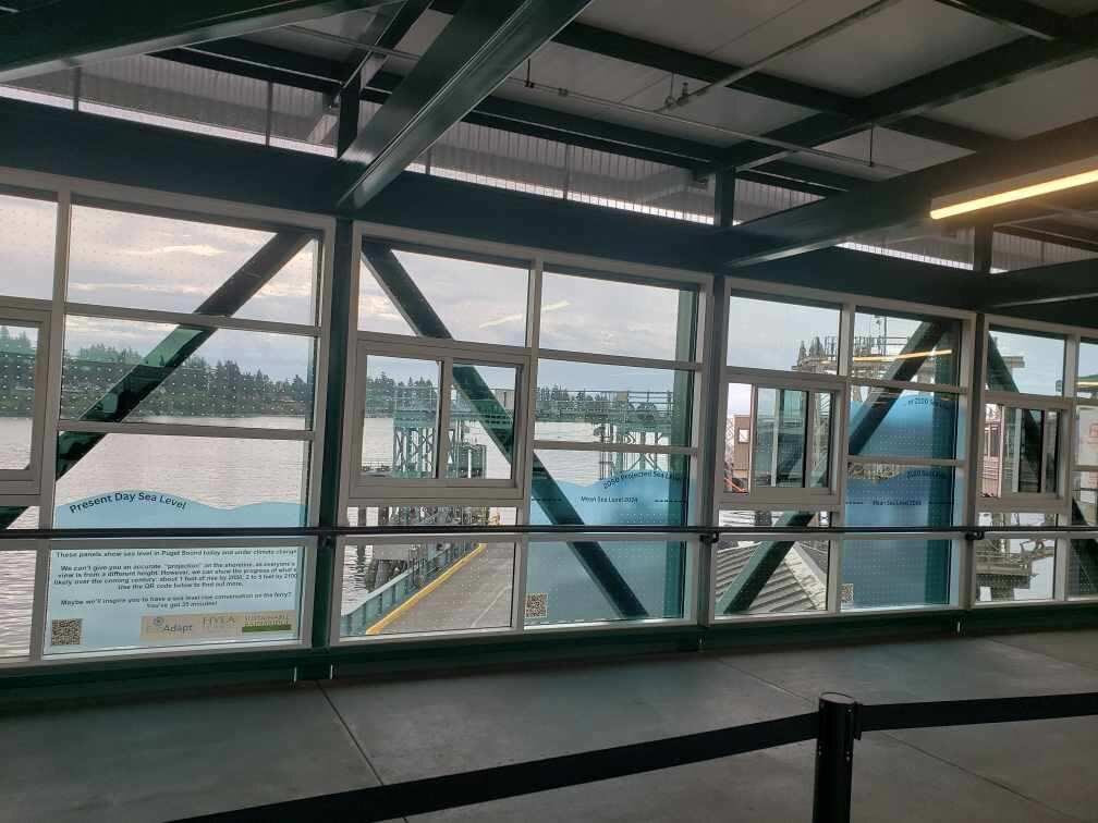 Sea level rise infographics on the windows at Bainbridge terminal overhead walkway
