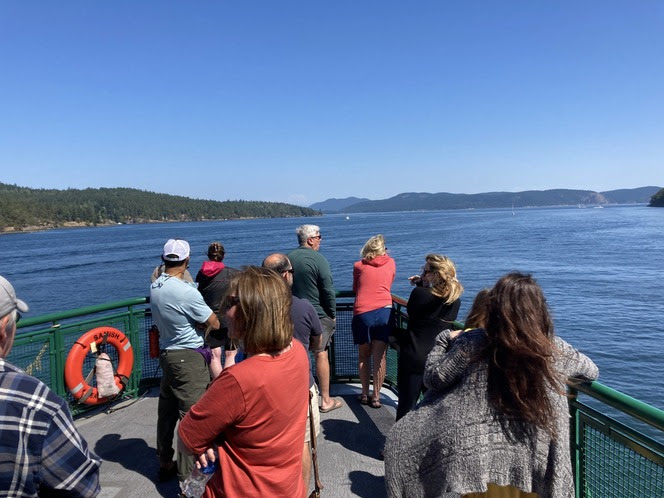 Several people on the outdoor deck of a ferry