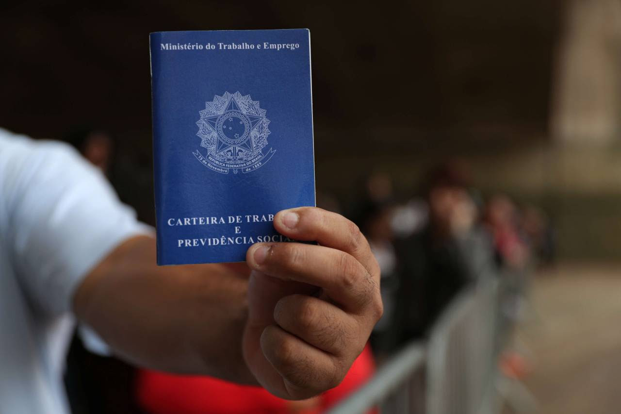 Homem mostra carteira de trabalho no centro de São Paulo (Foto: Amanda Perobelli/Reuters)