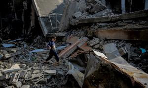 Un niño camina sobre los escombros de una casa destruida en la calle Omar Al-Mukhtar Street, en Gaza.