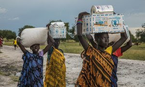 Unas mujeres transportan la ayuda alimentaria recibida en un punto de distribución de emergencia del PMA en Thaker, estado de Unity, Sudán del Sur (archivo).