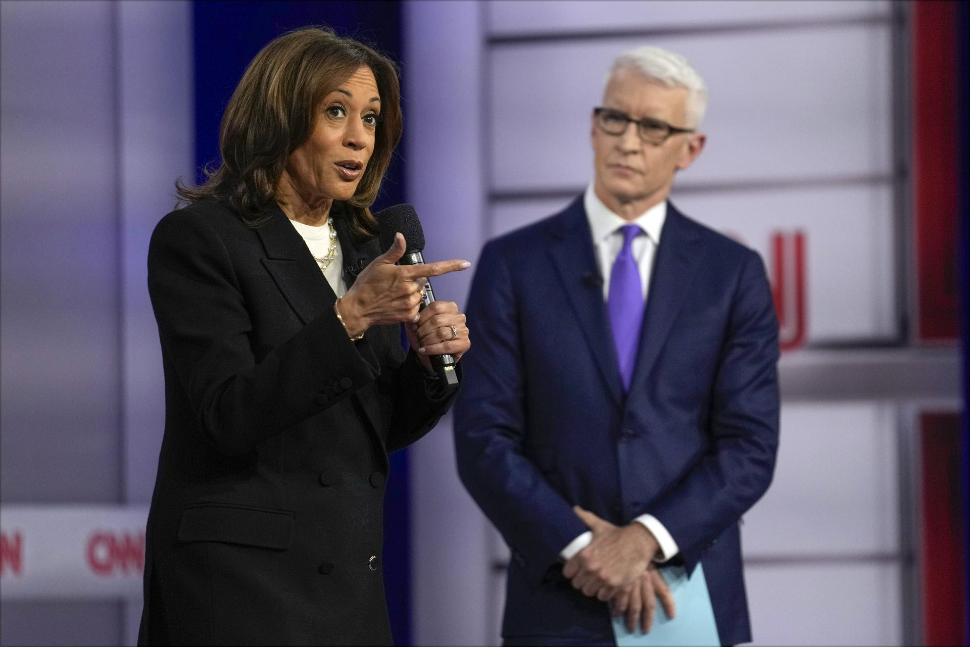 Kamala Harris speaks during a CNN town hall as moderator Anderson Cooper listens. 