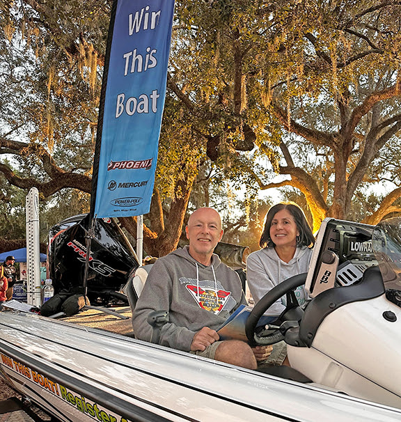 2 people sitting in a Phoenix bass boat