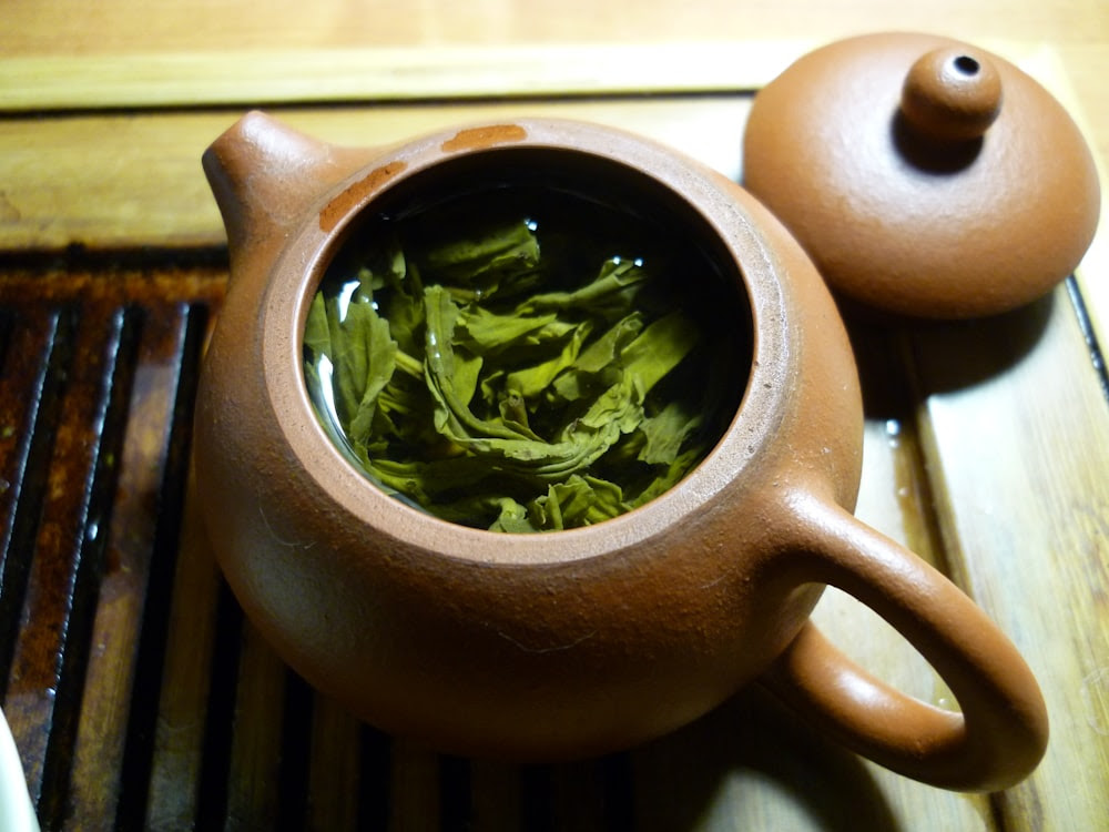 green leaves and clear liquid inside teapot