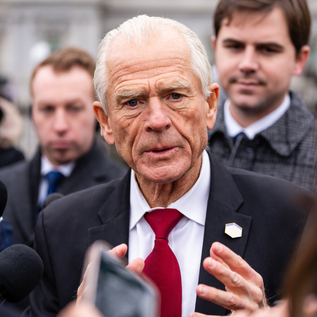 Peter Navarro gesturing with both hands while speaking to reporters.