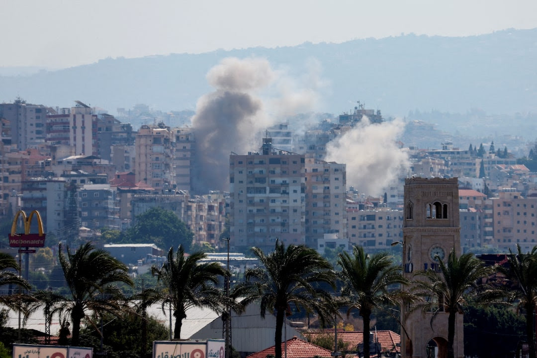 Smoke billows from damaged buildings over southern Lebanon following an Israeli strike, amid ongoing cross-border hostilities between Hezbollah and Israeli forces, as seen from Tyre, Lebanon.