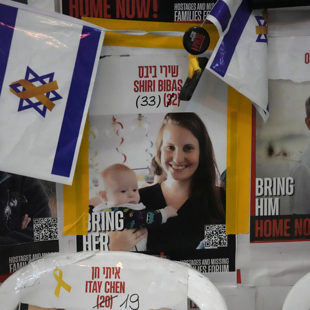 A missing person poster shows Shiri Bibas holding her baby.