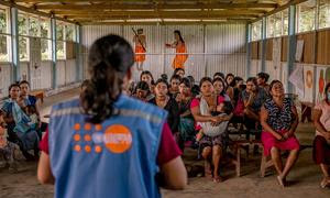 Sesión previa a la entrega de kits de dignidad en la comunidad. En la foto, con chaleco y de espaldas, la obstetra Marilú Ravines da una charla informativa a las mujeres beneficiarias de esta entrega.