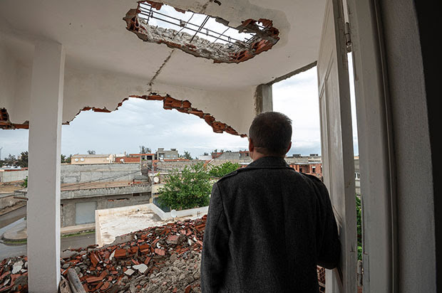 Man looking out a destroyed building